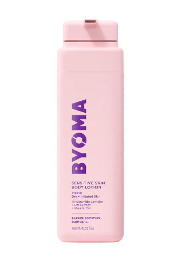 A pink bottle of BYOMA sensitive skin body lotion with white and purple text on the label.